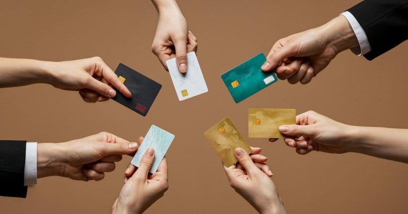 Varias mãos segurando vários Cartões de credito.