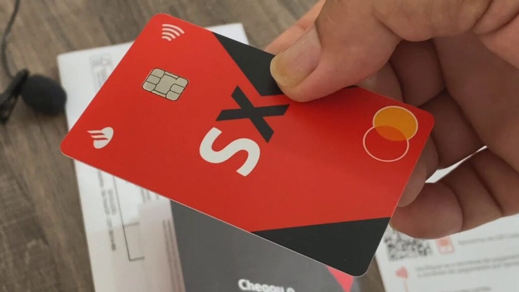 Mão segurando cartão Santander SX